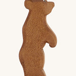A Ostheimer wooden small brown standing bear figure on a cream background.