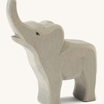 A small wooden trumpeting Ostheimer figure on a cream background.