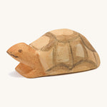 A small wooden Ostheimer turtle on a cream background