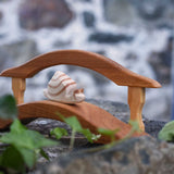 An Ostheimer wooden snail figure placed on the Ostheimer wooden bridge with railing. These wooden toys are part of a wide range of Ostheimer figures available at Babipur.