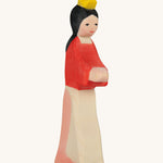 A wooden Ostheimer wooden snow white figure wearing a white and pink skirt, a red top and a yellow crown on a cream background.