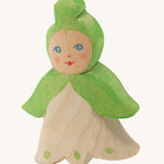 A wooden Ostheimer snowflake flower child figure on a cream background.