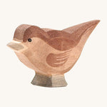 A wooden Ostheimer sparrow bird figure on a cream background.