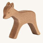 A wooden standing Ostheimer deer figure on a cream background.