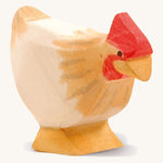 A ochre wooden standing Ostheimer hen figure on a cream background.
