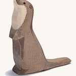 A wooden standing Ostheimer sea otter figure on a cream background