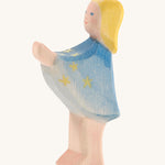 A wooden Ostheimer star taler figure wearing a blue cape with gold stars on a cream background.