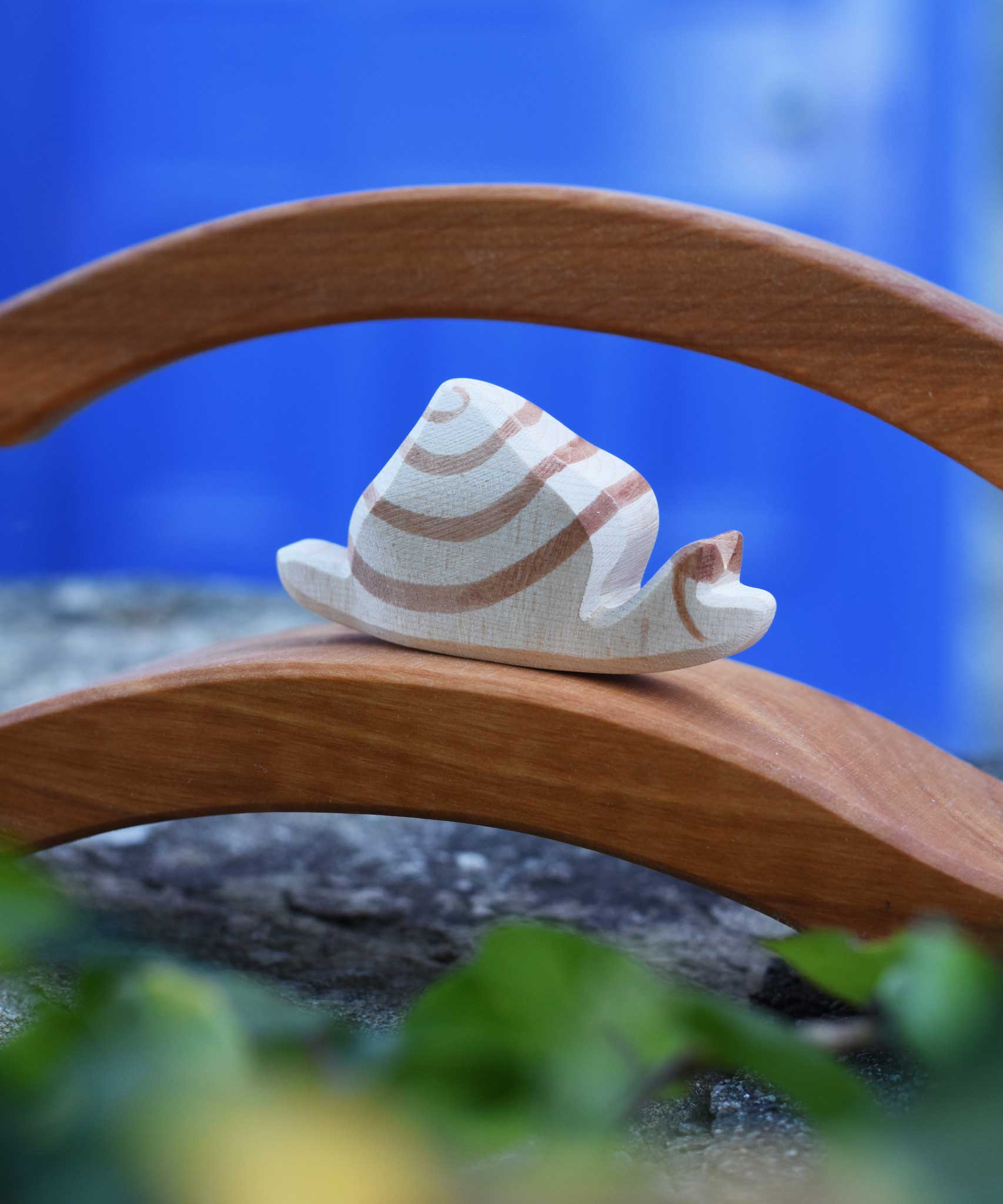 A close up of the Ostheimer snail figure on a wooden bridge. The wooden snail figure has a cream white coloured base with brown detailing.