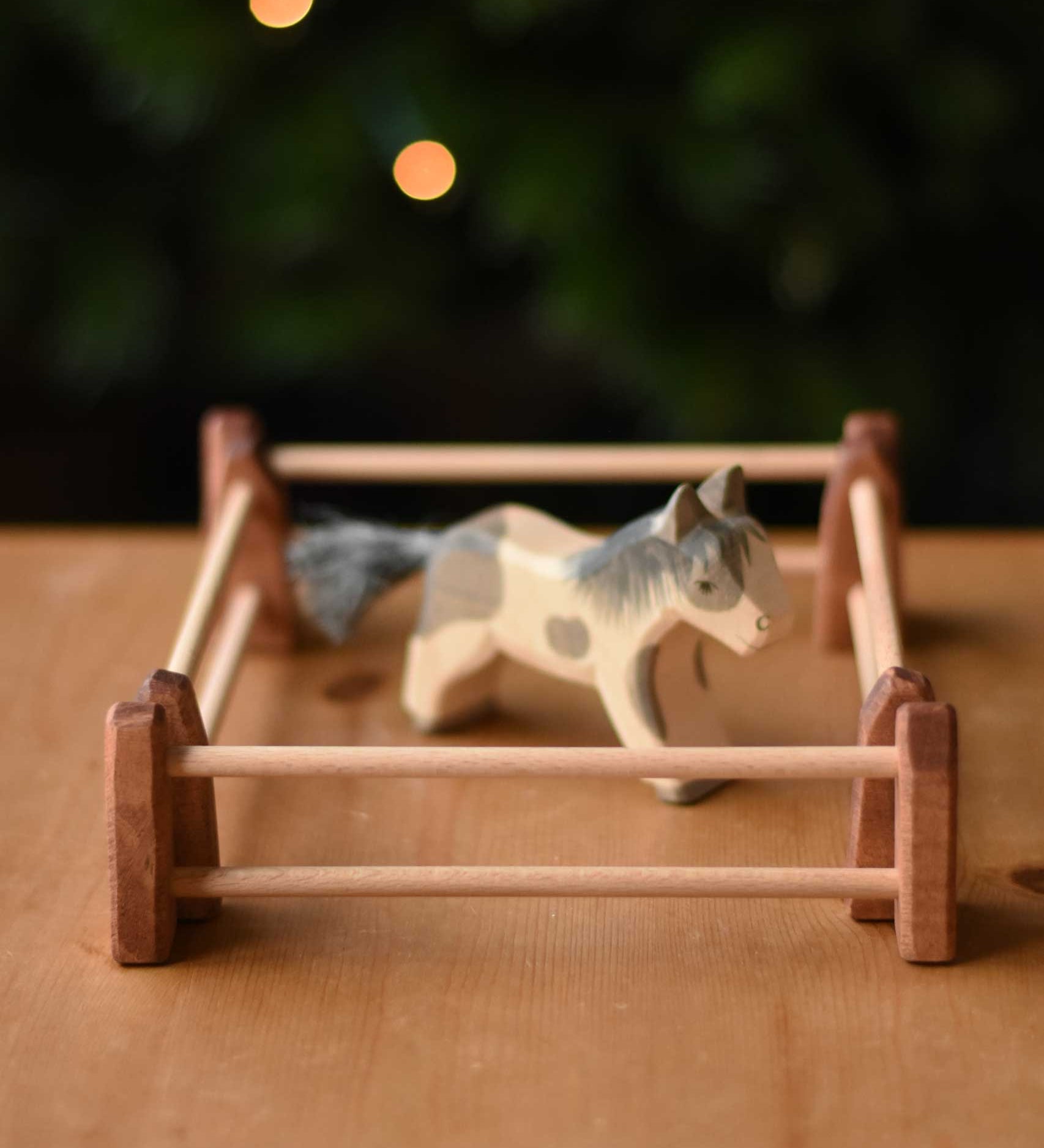 An Ostheimer Shetland pony wooden toy figure surrounded by 4 small wooden toy fences used to create an enclosure.  These wooden figures are part of a wide range of expertly hand crafted wooden toys here at Babipur. 