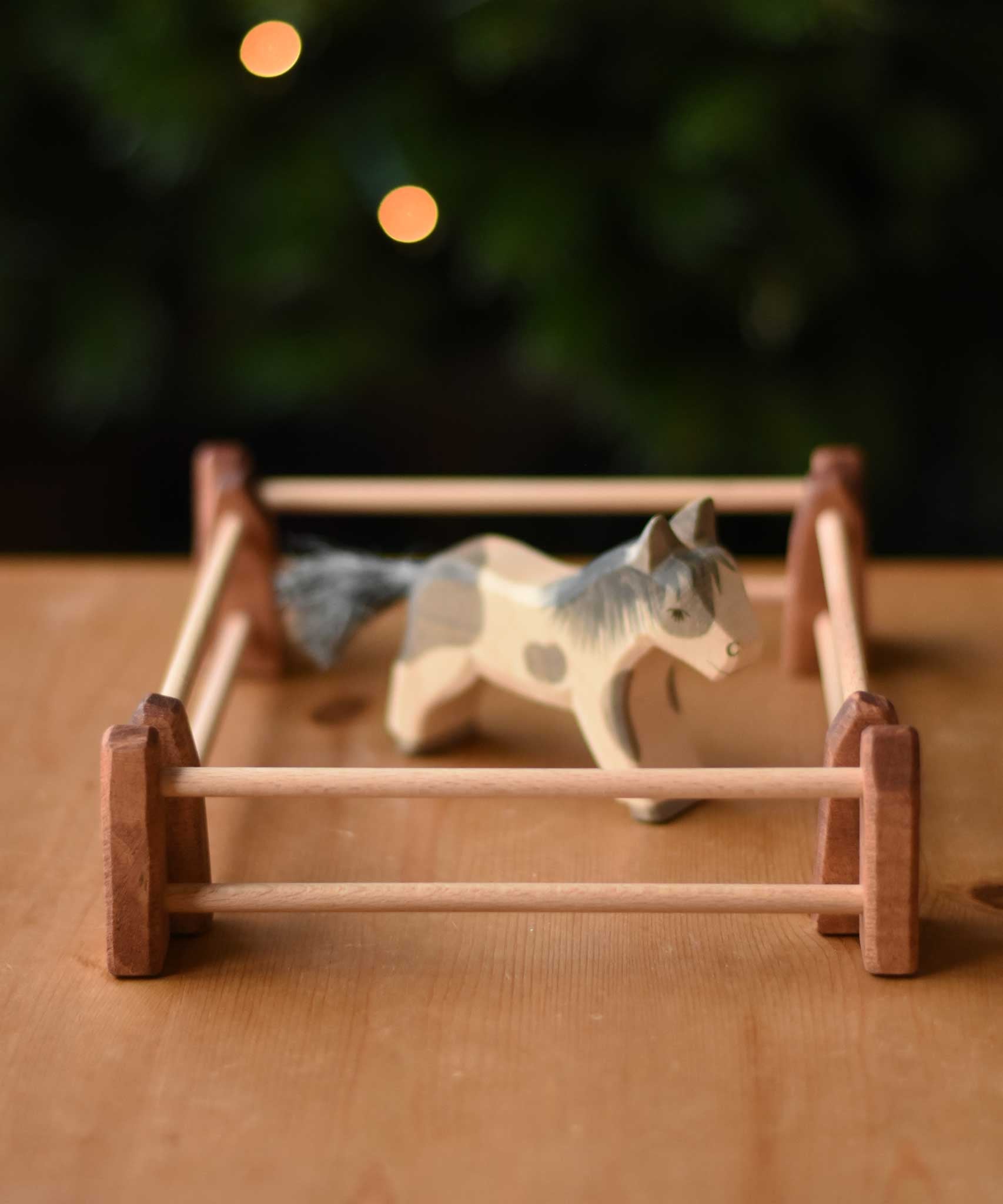 An Ostheimer Shetland pony wooden toy figure surrounded by 4 small wooden toy fences used to create an enclosure.  These wooden figures are part of a wide range of expertly hand crafted wooden toys here at Babipur. 