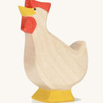 A wooden Ostheimer hen toy with it's head facing up on a plain background. 