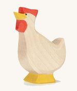 A wooden Ostheimer hen toy with it's head facing up on a plain background. 