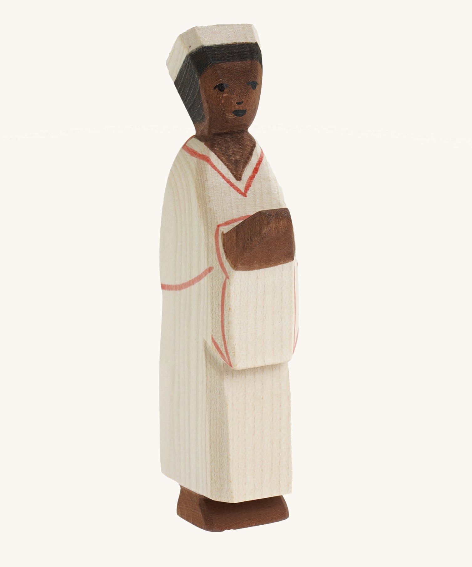 The Ostheimer hand carved wooden toy Nativity man figure, he wears simple cream robes and a hat.