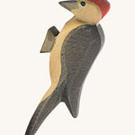 A wooden Ostheimer woodpecker figure on a cream background.