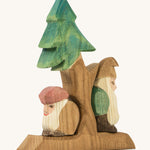 A wooden Ostheimer fir tree with Ostheimer dwarves standing on the stand on a cream background.