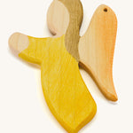 A yellow wooden angel figure on a cream background