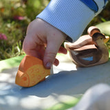 Ostheimer yellow fish handmade wooden toy figure being played with by a child. 