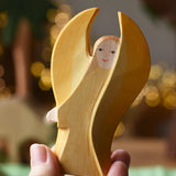 Ostheimer yellow guardian angel wooden toy figure in an adult's hand.