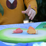 Ostheimer red and yellow handmade wooden toy figures placed on pond piece. 