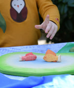 Ostheimer red and yellow handmade wooden toy figures placed on pond piece. 