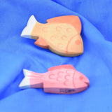Ostheimer yellow and red fish wooden toy figures placed on a  blue Laura's cotton play cloth.