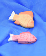 Ostheimer yellow and red fish wooden toy figures placed on a  blue Laura's cotton play cloth.