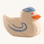 A wooden Ostheimer pigeon figure on a cream background.