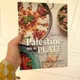 The hardcover cookbook 'Palestine on a Plate' by chef and activist Joudie Kalla. The front cover features vibrant Middle Eastern mezze plates.