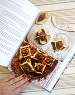 The cookbook 'Palestine on a Plate' open to reveal one of the recipes; it's a recipe for lamb pastry parcels with pomegranate; a traditional middle eastern food.