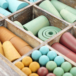 Close up of the Papoose hand carved wooden earth tinker tray toys in their wooden crate on a white background