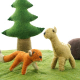 Close up of the Papoose felt fox and fawn toy figures on a green play mat in front of a Papoose tree