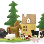 sheep and dog toys on a Papoose play mat in front of a wooden house