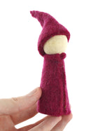 Close up of a hand holding a Papoose rainbow gnome toy on a white background