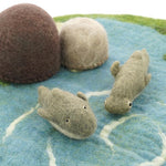 Close up of the Papoose soft dolphin and hammerhead shark toy figures on a blue play mat in front of some Papoose rocks