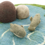 Close up of the Papoose soft dolphin and hammerhead shark toy figures on a blue play mat in front of some Papoose rocks