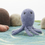 Close up of the Papoose purple octopus figure on a blue play mat in front of some Papoose rocks