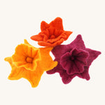 Close up of some Papoose plastic-free rainbow daffodils on a green play mat next to a Papoose bright elf figure