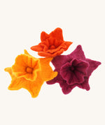 Close up of some Papoose plastic-free rainbow daffodils on a green play mat next to a Papoose bright elf figure