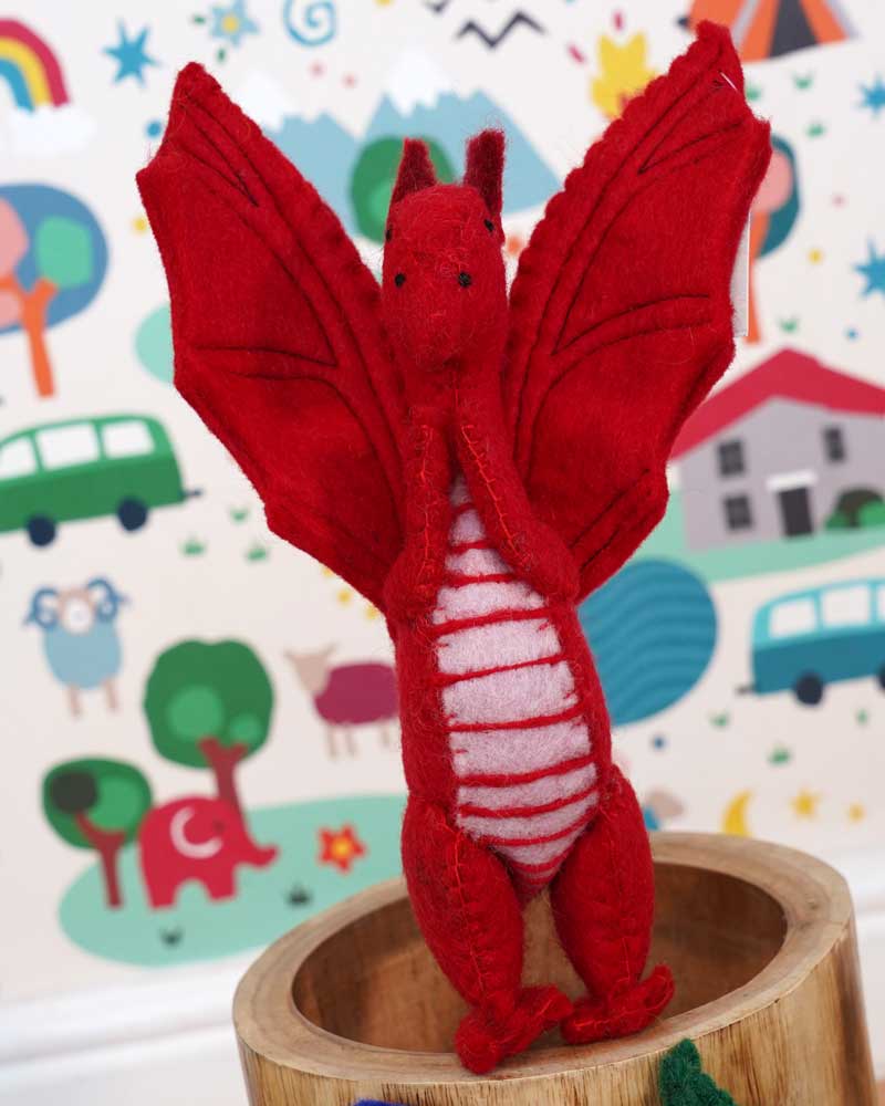 A close up of a Papoose red felted dragon in a playroom showing the stitching detail and facial features.