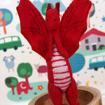 A close up of a Papoose red felted dragon in a playroom showing the stitching detail and facial features.