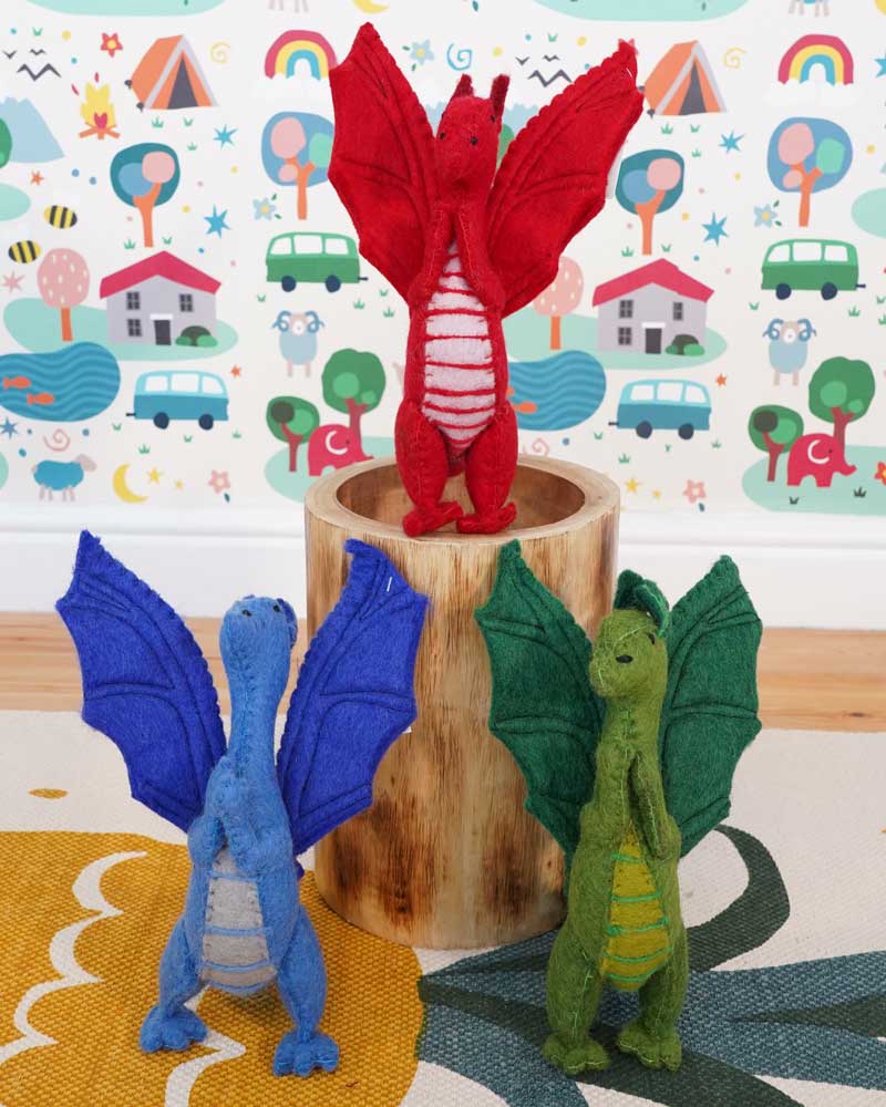 A blue, green and red dragon standing in a playroom 