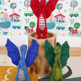A blue, green and red dragon standing in a playroom 