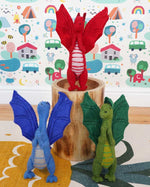 A blue, green and red dragon standing in a playroom 