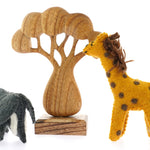 Papoose childrens handmade felt elephant and giraffe toys on a white background next to a Papoose wooden African tree