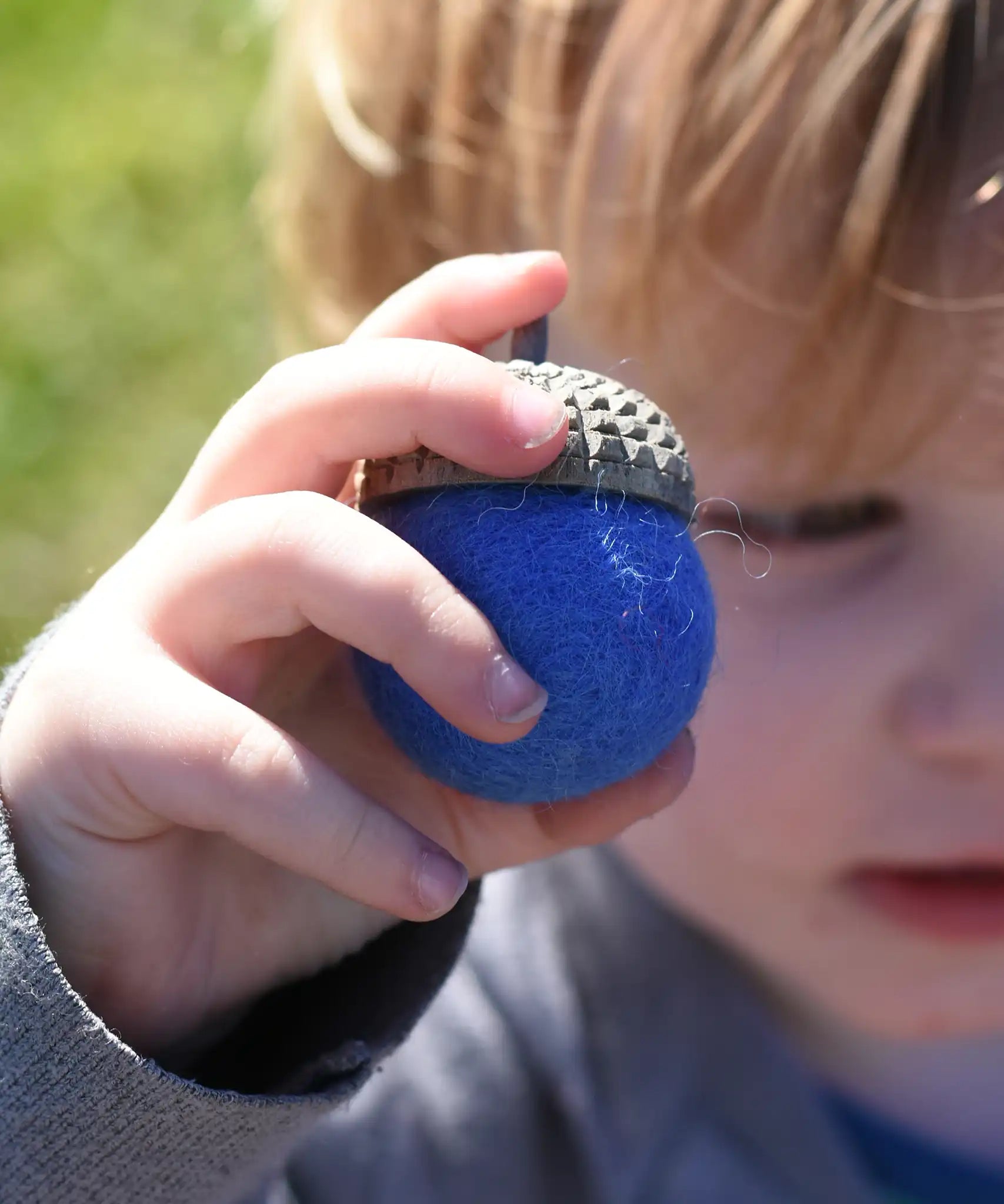 Blue Papoose Toys felt acorns in a child's hands.