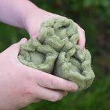 Close up of three Papoose Toys felt cabbage play food in a child's hands.