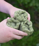 Close up of three Papoose Toys felt cabbage play food in a child's hands.