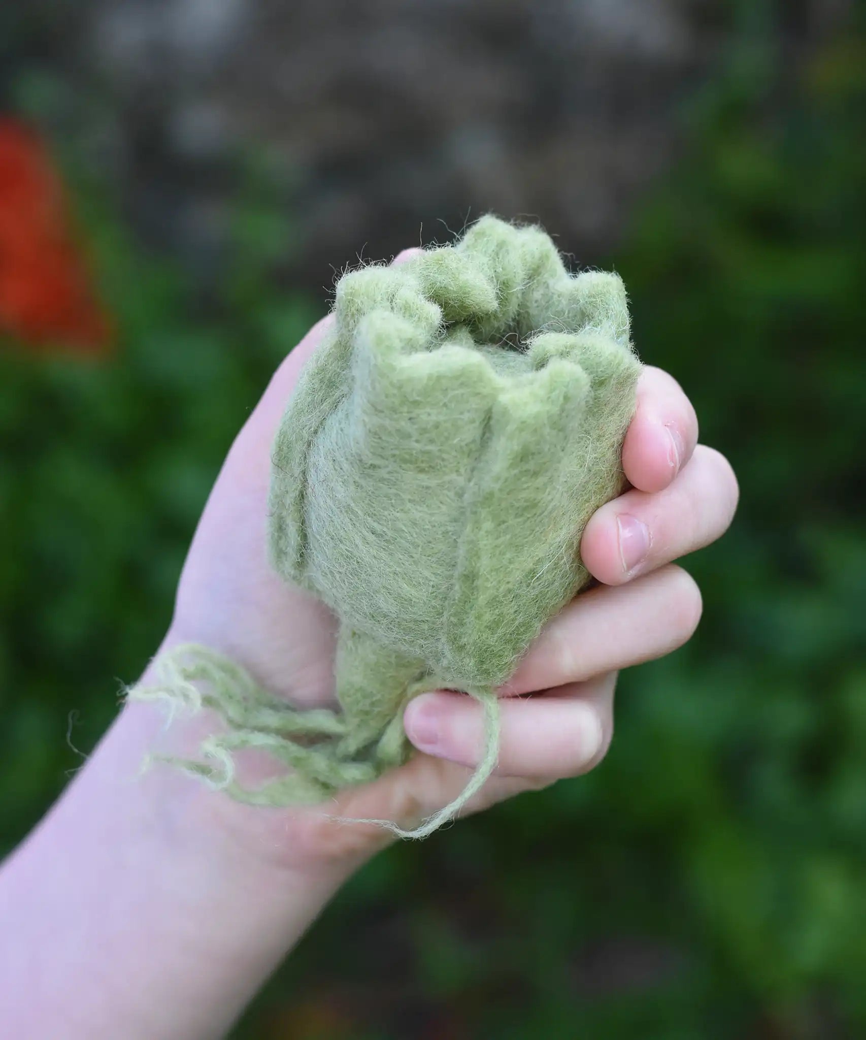 Papoose Toys felt cabbage play food in a child's hand. 