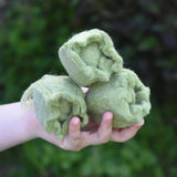 Papoose Toys felt cabbage in a set of three in a child's hands. 