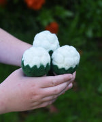 Papoose Toys felt cauliflower set of three in a child's hand.